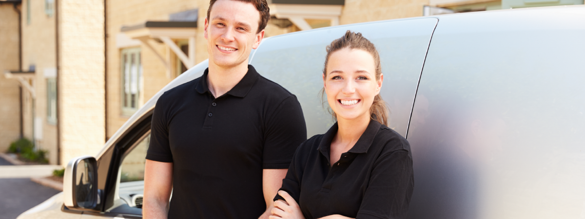 Man and Woman business owner standing in front of a van